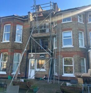 Rear elevation scaffolding at a two-storey property in Surbiton, Greater London, showing a 2.4m tower scaffold providing safe access to a party wall with working platform and edge protection.